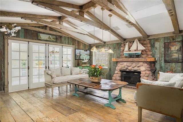 living room featuring vaulted ceiling with beams, wood-type flooring, a fireplace, and wood walls