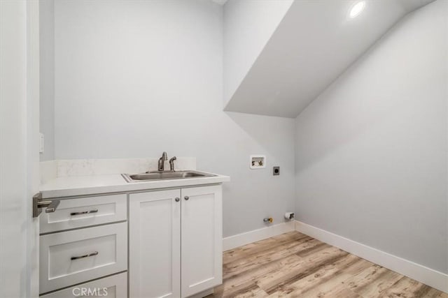 washroom featuring sink, cabinets, washer hookup, hookup for an electric dryer, and light wood-type flooring