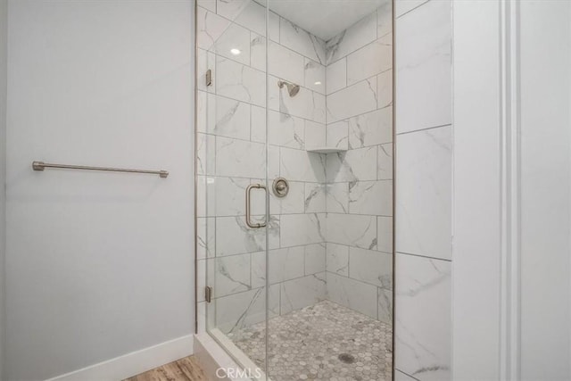 bathroom with hardwood / wood-style flooring and an enclosed shower