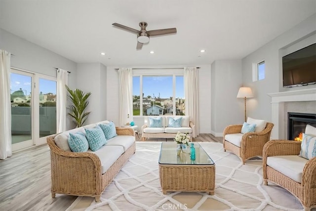 living room featuring ceiling fan and light hardwood / wood-style floors