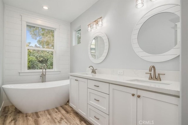 bathroom featuring hardwood / wood-style flooring, vanity, and a bathtub