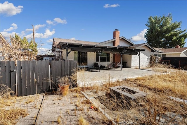 back of property with a pergola and a patio