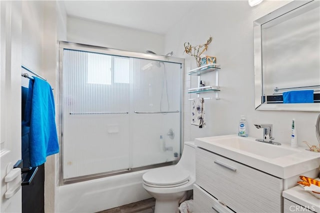 full bathroom with vanity, shower / bath combination with glass door, and toilet