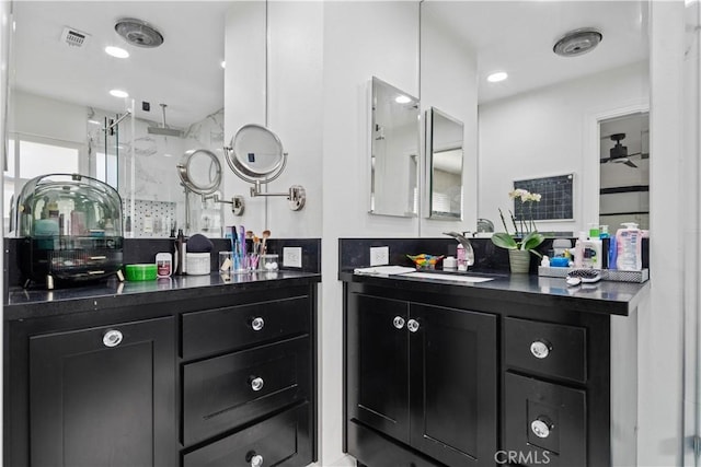 bathroom with walk in shower, ceiling fan, and vanity