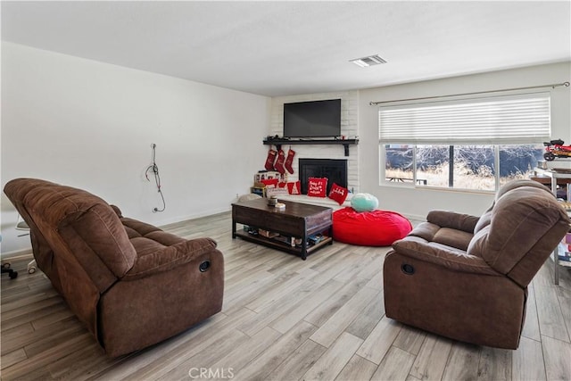 living room with a fireplace and light hardwood / wood-style floors