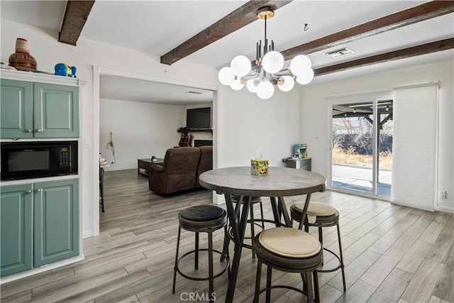 dining space with beamed ceiling, a notable chandelier, and light wood-type flooring