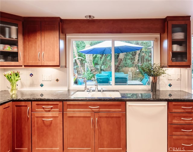 kitchen featuring dark stone countertops, sink, tasteful backsplash, and dishwasher