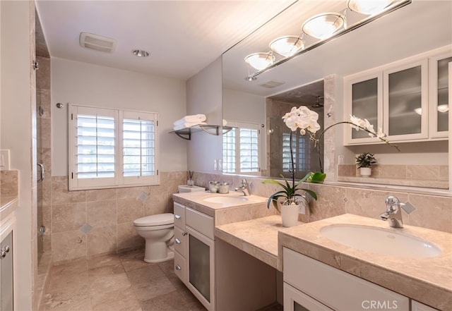 bathroom with vanity, tile walls, an enclosed shower, and toilet