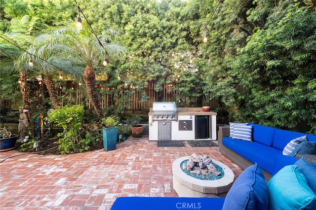 view of patio / terrace featuring area for grilling and an outdoor living space with a fire pit