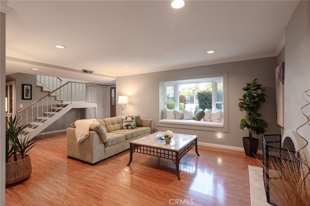 living room featuring crown molding and light wood-type flooring