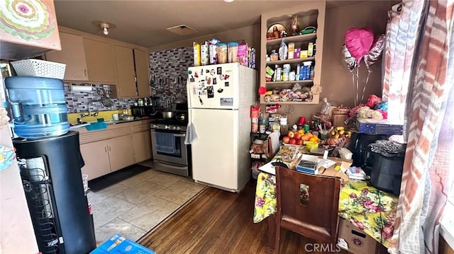 kitchen featuring stainless steel range oven, sink, white fridge, and light hardwood / wood-style flooring