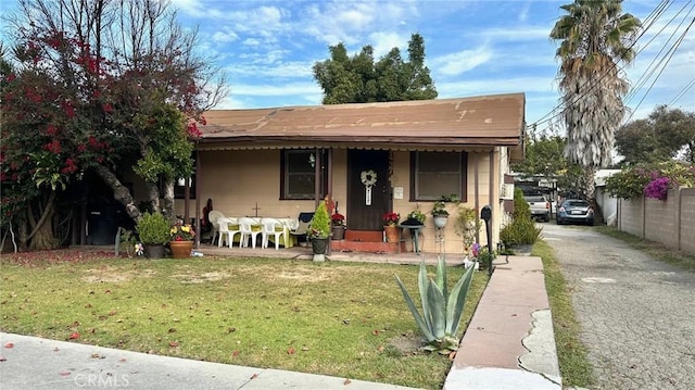 bungalow-style home with covered porch and a front lawn