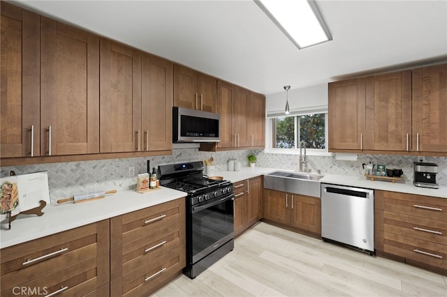 kitchen featuring tasteful backsplash, sink, hanging light fixtures, and appliances with stainless steel finishes