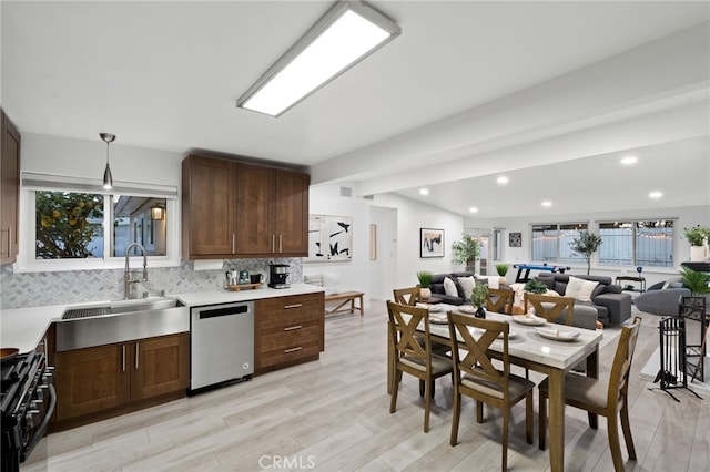 kitchen with pendant lighting, sink, black range with gas cooktop, decorative backsplash, and stainless steel dishwasher