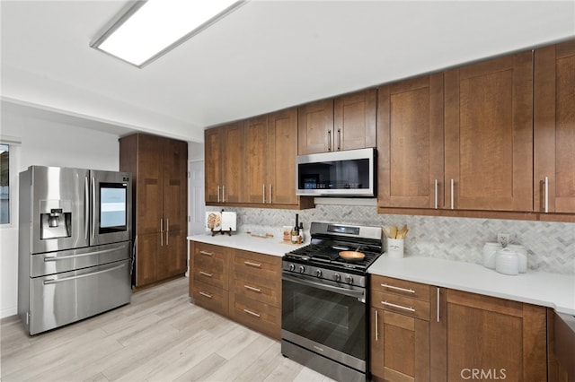 kitchen featuring tasteful backsplash, stainless steel appliances, and light hardwood / wood-style floors