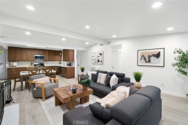 living room with light hardwood / wood-style flooring and vaulted ceiling with beams