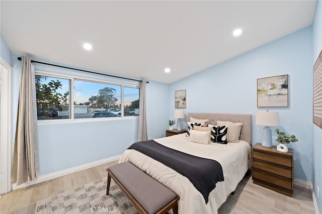 bedroom with vaulted ceiling and light hardwood / wood-style floors