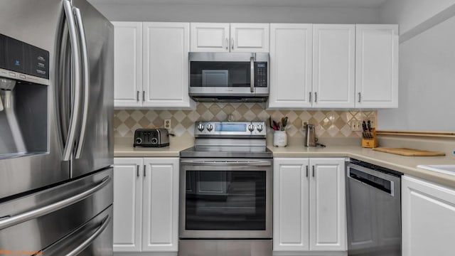 kitchen with stainless steel appliances, white cabinetry, tasteful backsplash, and sink