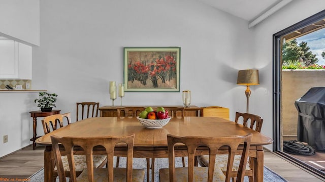 dining room featuring vaulted ceiling and light hardwood / wood-style floors