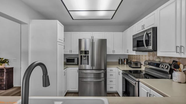 kitchen featuring tasteful backsplash, appliances with stainless steel finishes, and white cabinets