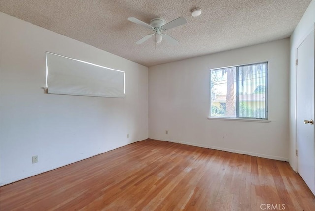 spare room with ceiling fan, light hardwood / wood-style flooring, and a textured ceiling