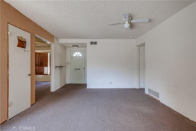 carpeted empty room with ceiling fan and a textured ceiling