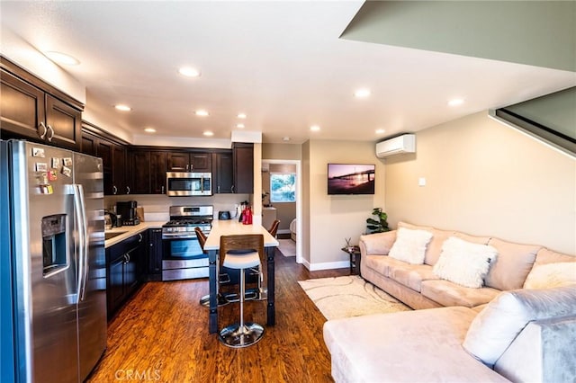 kitchen with open floor plan, appliances with stainless steel finishes, dark wood finished floors, and a wall mounted air conditioner