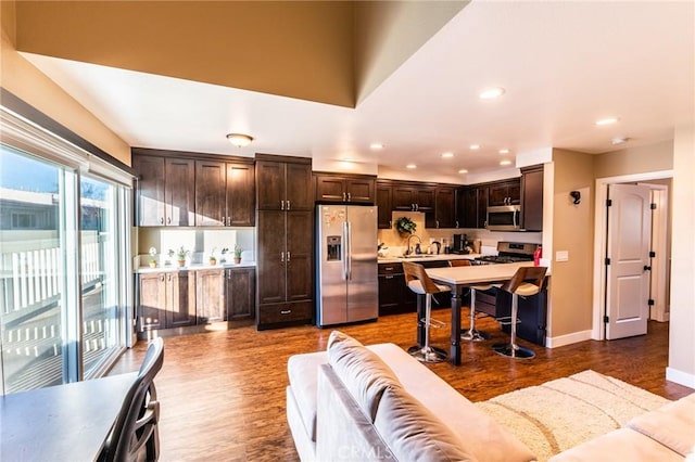 living area with recessed lighting, baseboards, and wood finished floors