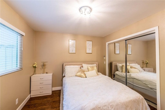 bedroom featuring baseboards, a closet, and dark wood finished floors