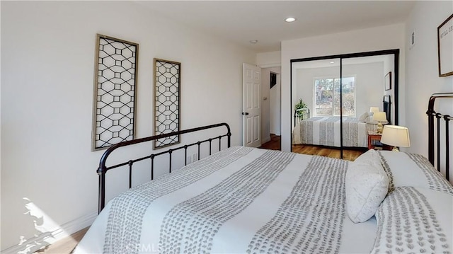 bedroom with hardwood / wood-style floors and a closet