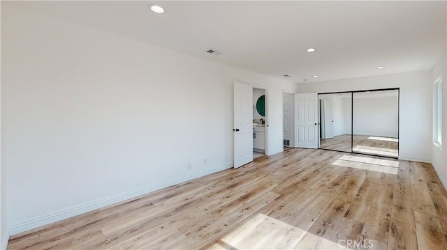 unfurnished bedroom featuring a closet and light hardwood / wood-style flooring