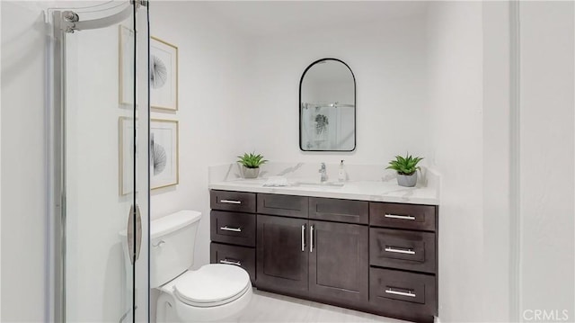 bathroom featuring vanity, a shower, and toilet