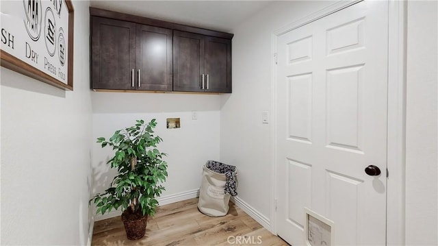 washroom with hookup for a washing machine and light wood-type flooring