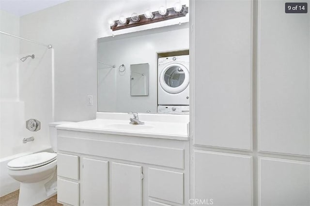 full bathroom featuring stacked washer and dryer, vanity, toilet, and tub / shower combination