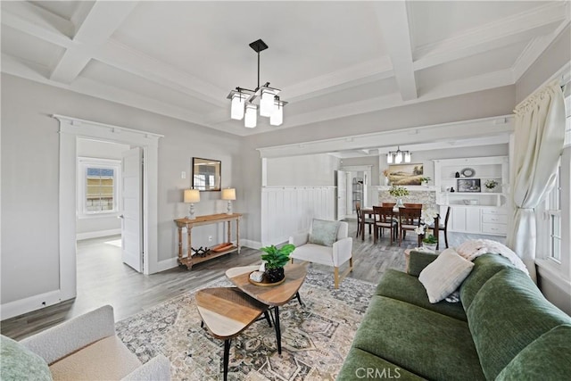 living room featuring coffered ceiling, a notable chandelier, hardwood / wood-style flooring, and beamed ceiling