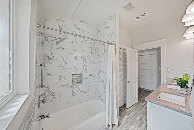 bathroom featuring shower / tub combo, vanity, vaulted ceiling, and hardwood / wood-style floors