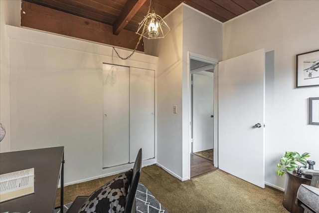 carpeted office space featuring beam ceiling and wooden ceiling