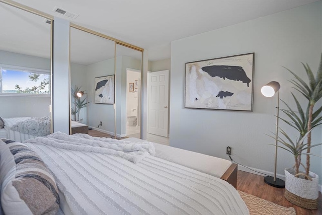 bedroom with multiple closets and light wood-type flooring