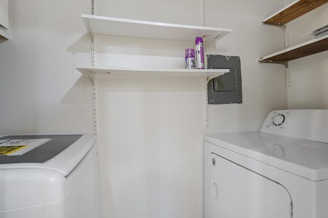 laundry room featuring electric panel and washer and clothes dryer