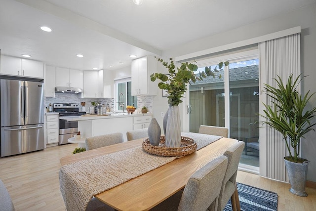 dining area with sink, plenty of natural light, and light wood-type flooring