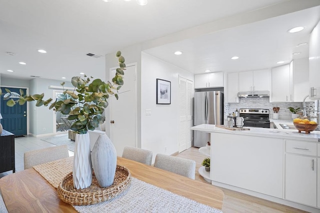 dining area featuring sink and light hardwood / wood-style flooring