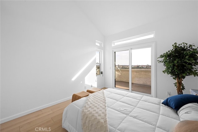 bedroom with high vaulted ceiling, access to exterior, and light wood-type flooring