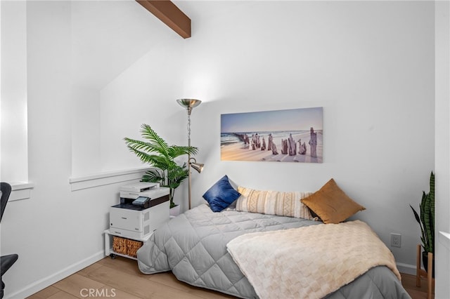 bedroom with light hardwood / wood-style flooring and vaulted ceiling with beams