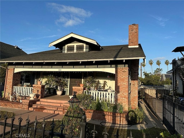 back of house featuring brick siding, fence, and a chimney