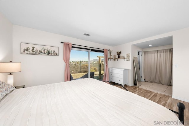 bedroom with access to outside and light wood-type flooring