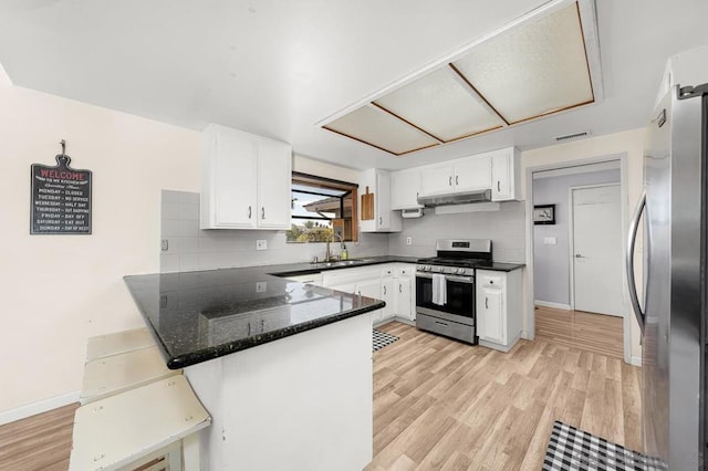 kitchen featuring white cabinetry, appliances with stainless steel finishes, sink, and kitchen peninsula