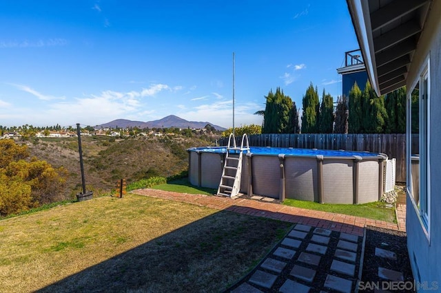 view of yard featuring a fenced in pool and a mountain view