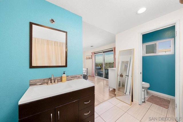 bathroom featuring vanity, tile patterned floors, and toilet