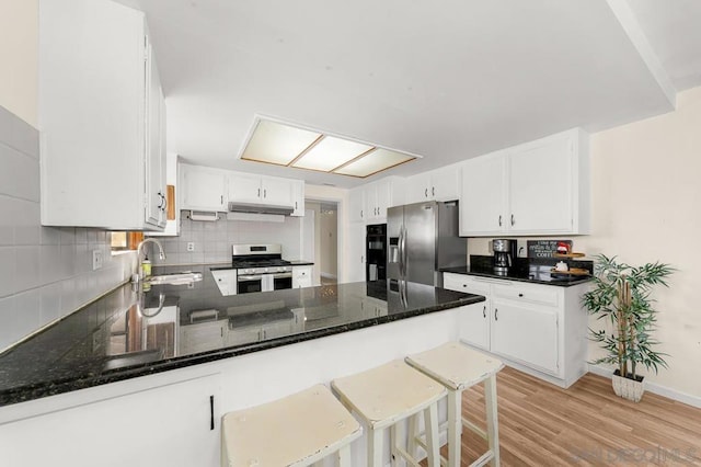 kitchen with sink, stainless steel appliances, kitchen peninsula, and white cabinets