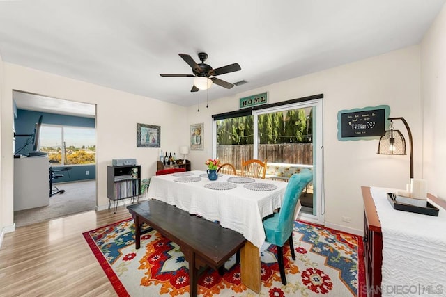 dining space with ceiling fan and light wood-type flooring